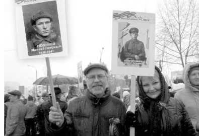 Супруги Виталий и Марина Тяжелковы с портретами дедушек-фронтовиков